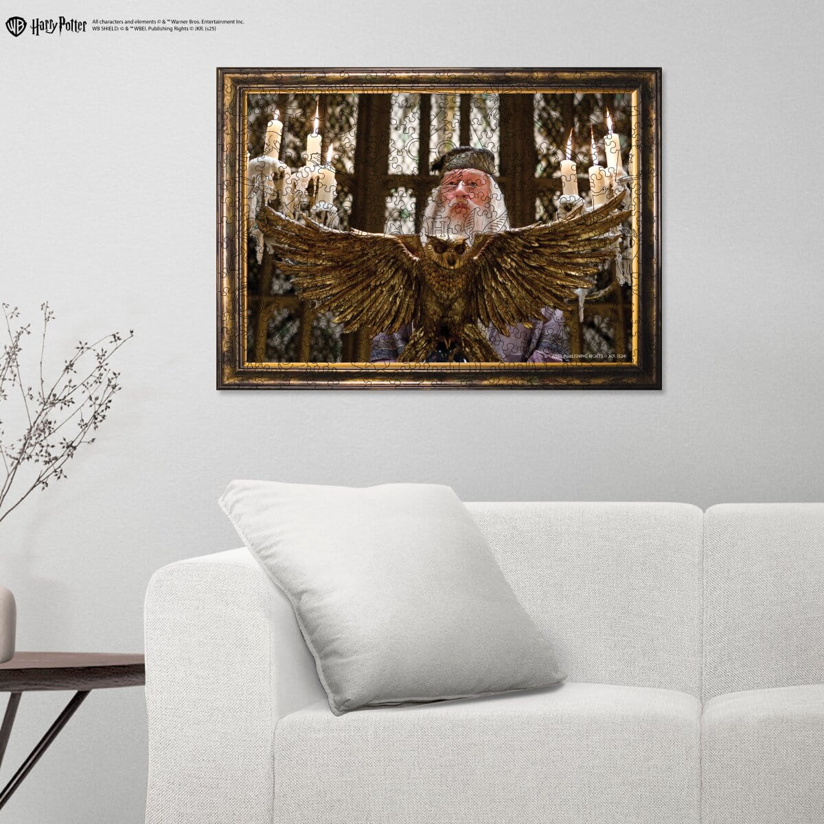 Framed artwork of a character with wings in a room with a sofa and decorative items.