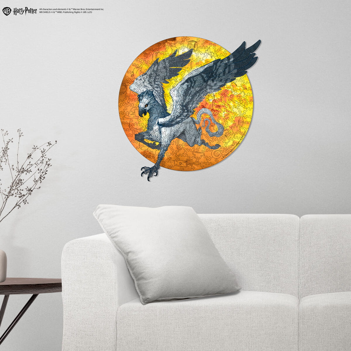 Decorative wall art of a winged creature on a yellow and orange circular background in a living room.