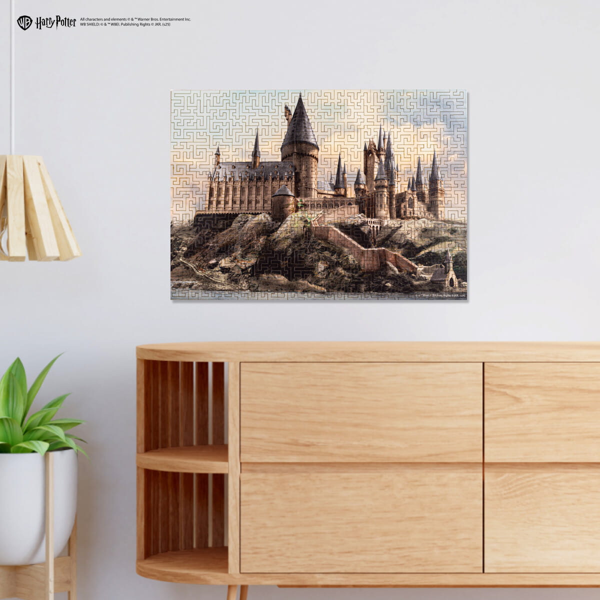 Jigsaw puzzle of a castle on a wall above a wooden cabinet with a plant.