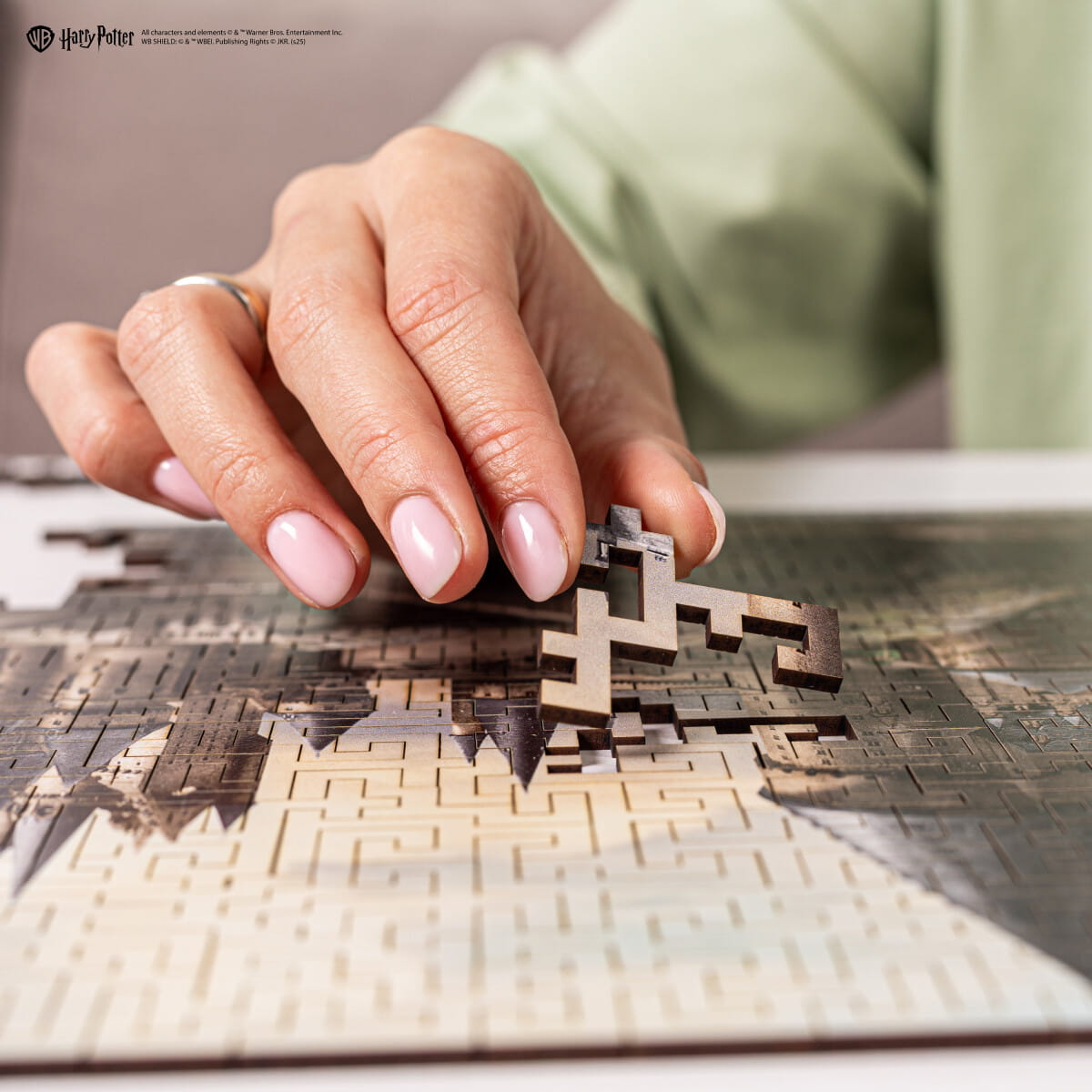 Hand placing a puzzle piece on a Harry Potter-themed puzzle