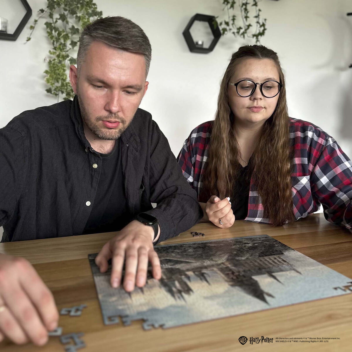 Man and woman working on a puzzle together at a table.