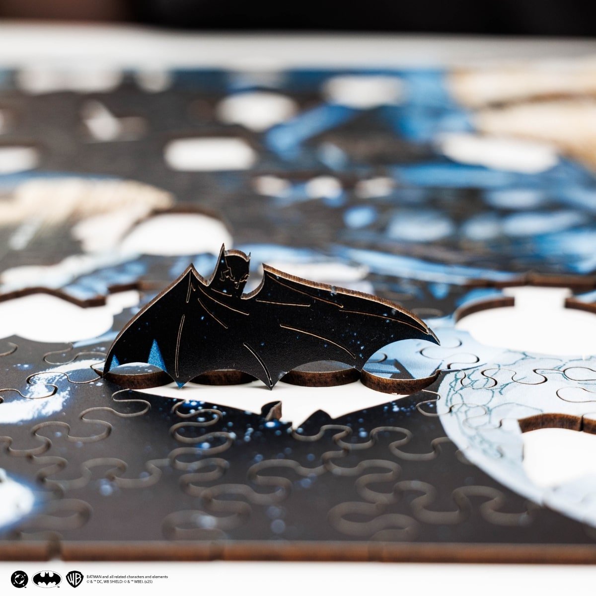 Black bat-shaped cookie on a puzzle with a blurred background