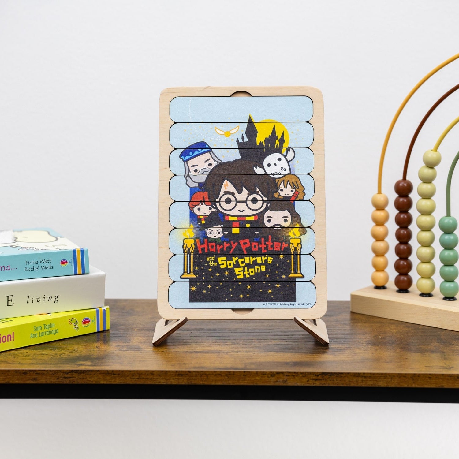 Children's book with a Harry Potter illustration on a wooden stand, surrounded by books and a wooden abacus.