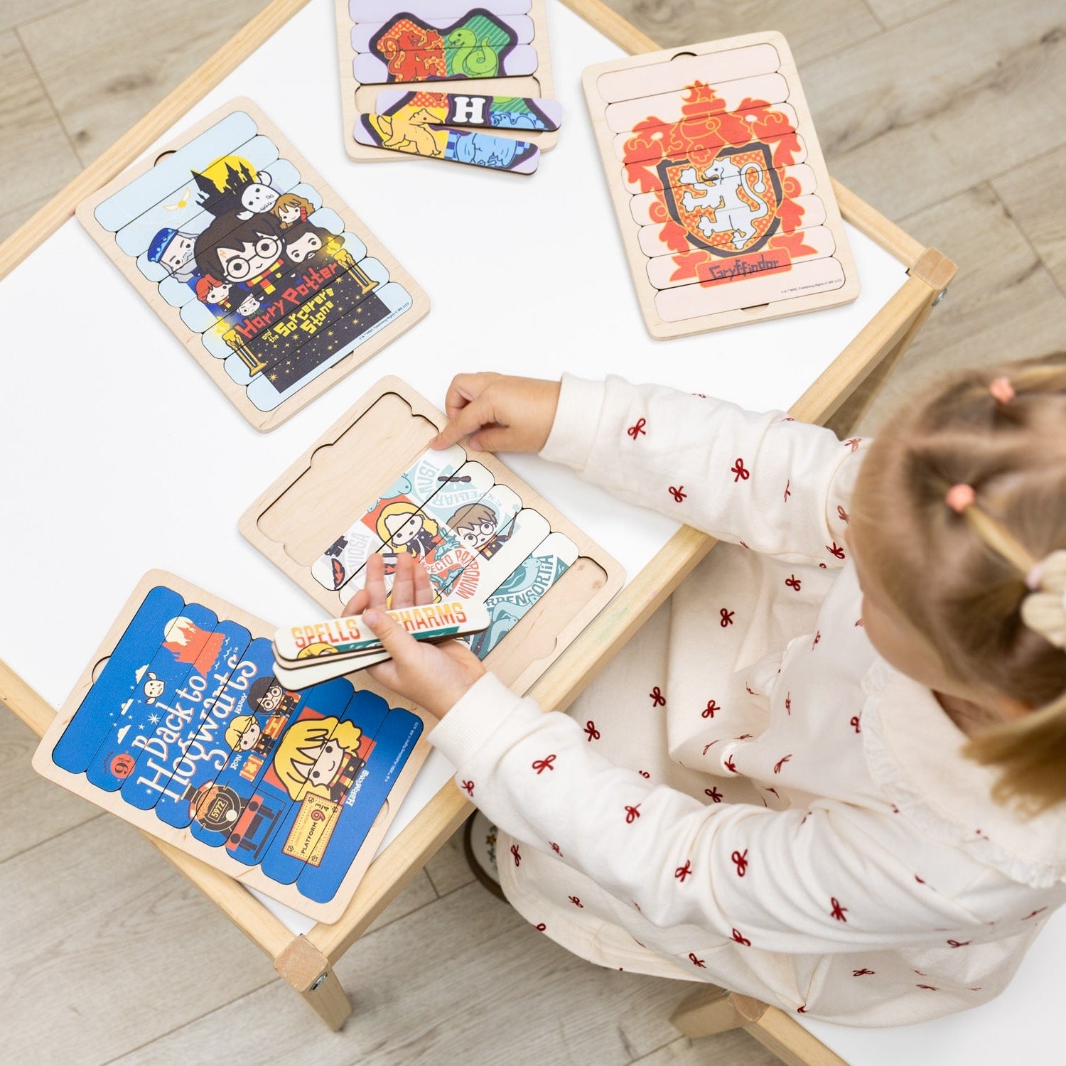 Child interacting with educational wooden boards on a table.