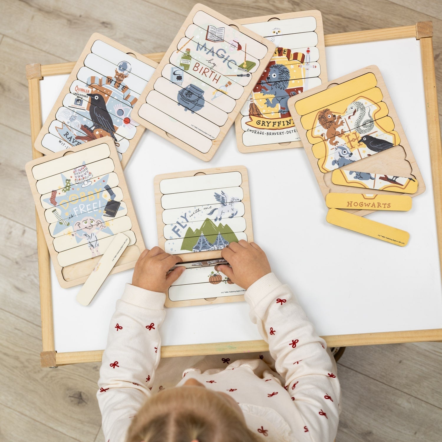 Child playing with educational cards on a wooden table