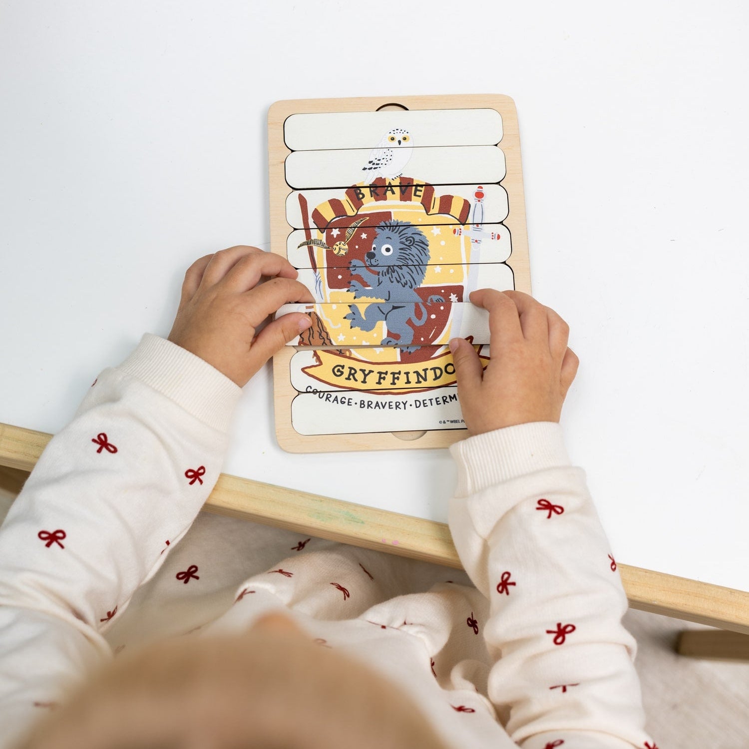 Child playing with a Harry Potter-themed wooden puzzle