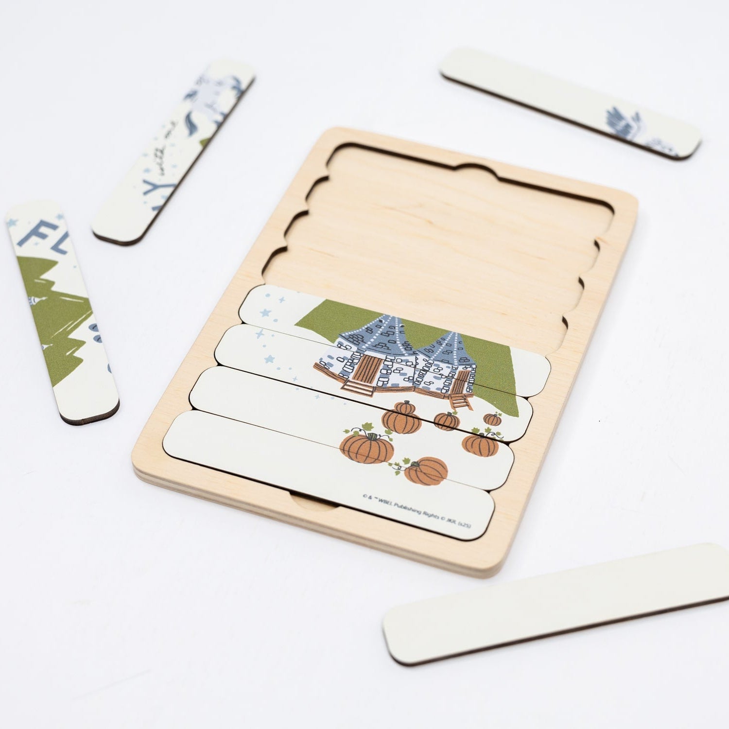 Wooden puzzle with a house and pumpkin design on a white background