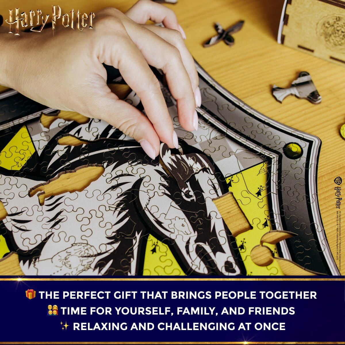 Hand assembling a puzzle with 'Harry Potter' theme on a wooden surface